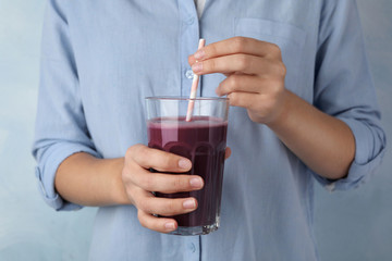 Woman with glass of fresh acai drink and straw, closeup
