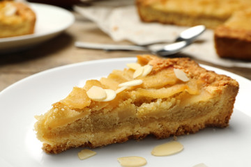 Piece of delicious sweet pear tart on table, closeup