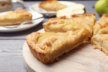 Cut delicious sweet pear tart on wooden table, closeup