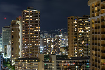 Fototapeta na wymiar The buildings of Honolulu, Hawaii, lit up at night
