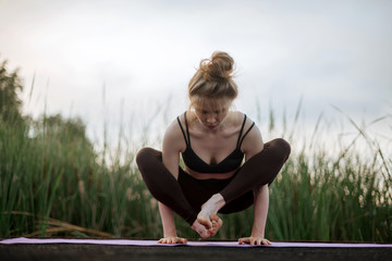 Girl practice yoga early morning on pier