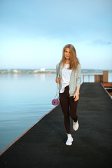 Girl on pier with yoga mat