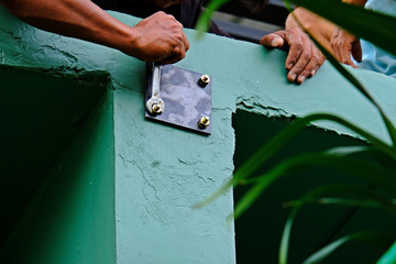 Worker tightening the sleeve anchor bolt (expansion bolt) to cling steel plate into concrete beam. 