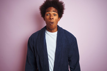 Young african american man wearing pajama standing over isolated pink background afraid and shocked with surprise expression, fear and excited face.