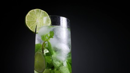 Fresh Mojito cocktail with lime, mint and ice in jar glass on dark background. Summer cold drink and cocktail
