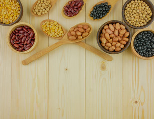 Flat lay,top view assorted beans including red bean,soybeans,black beans,mung beans on brown,beige wooden background with copy space 