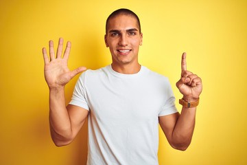 Young caucasian man wearing casual white t-shirt over yellow isolated background showing and pointing up with fingers number six while smiling confident and happy.