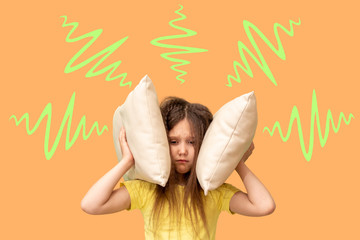 The little girl covered her ears with a pillow. Loud sound concept
