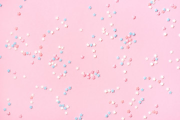 Confetti in the form of small stars on a pink background. Holiday concept.