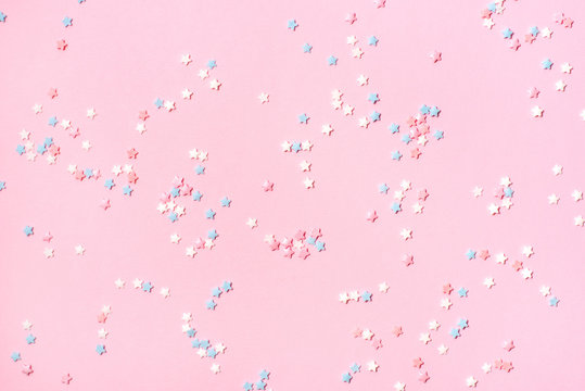 Confetti in the form of small stars on a pink background. Holiday concept.