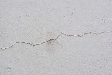 old white painted concrete wall with a crack running through it