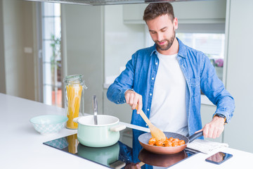 Handsome man cooking pasta at home