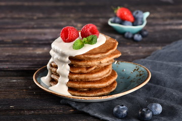 pancakes for Breakfast with sour cream raspberry mint blueberry strawberries on a platter