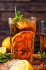 Iced tea with lemon and ice on a wooden background