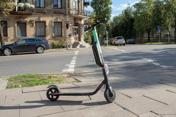 An electric scooter is parked at a crossroads in the city center.
