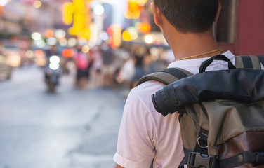 Back side of Young Asian traveling men walking and looking in china town walking street in evening at Bangkok, Thailand, traveler and tourist concept