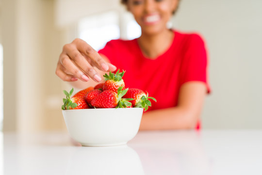 Close up of young woman eating fresh strawberries