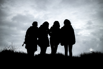Fototapeta na wymiar The silhouette of four girls after sunset