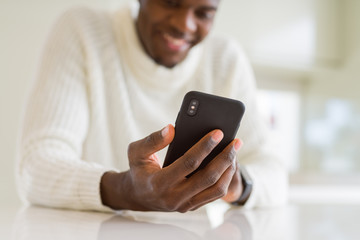 Close up of african business man hands using smarpthone and smiling
