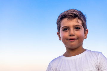 Beautiful face of a little kid against the blue sky