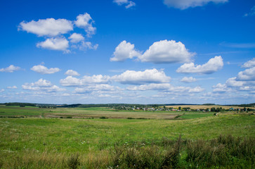 Rural beautiful landscape. Green field with blue sky.