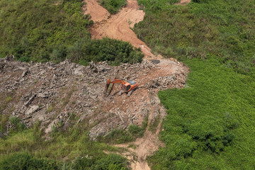 橙色大型挖掘机在野外工作时撞击碎石鸟瞰图