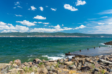 Rocky shore over the beautiful Black Sea, in Nessebar, Bulgaria. Sunny Beach hotels in the background.