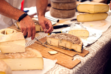Seller prepares cheese for the custumers at cheese festival. Organic and farm food