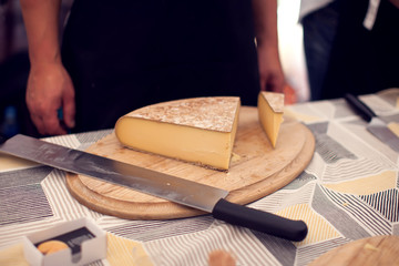 Seller prepares cheese for the custumers at cheese festival. Organic and farm food