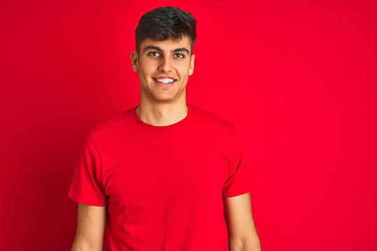 Young Indian Man Wearing T-shirt Standing Over Isolated Red Background With A Happy And Cool Smile On Face. Lucky Person.