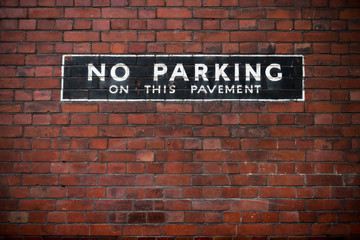 Fototapeta na wymiar No parking sign at a brick wall.
