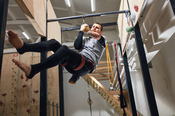 Low angle view of physically challenged rock-climber preparing to the international bouldering competition, doing dynamic and intentinsive trainings, powerful and strong willed person.