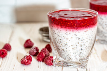Greek yogurt and chia seeds for breakfast with raspberry sorbet. In a glass on a wooden white background.