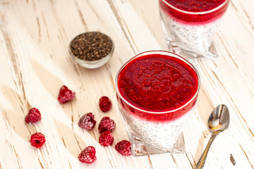Greek yogurt and chia seeds for breakfast with raspberry sorbet. In a glass on a wooden white background.