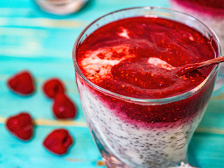 Greek yogurt and chia seeds for breakfast with raspberry sorbet. In a glass on a wooden blue background.