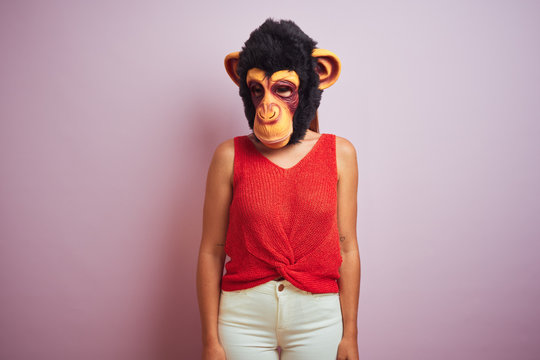 Woman standing wearing t-shirt and monkey mask