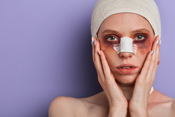 scared girl wrapped in medical bandage preparing for surgery, she wants to have beautiful face....