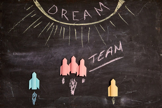 Unity and teamwork concept: Dreamteam, collaborate and cooperation. Group of paper rockets and the inscription.