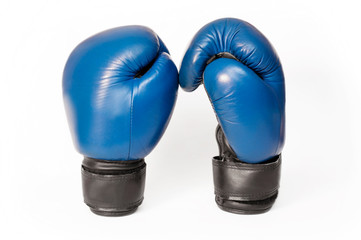 Two boxing gloves on a light background are facing each other as if they are going to try to compete