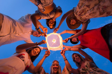 Group of friends lighting lanterns