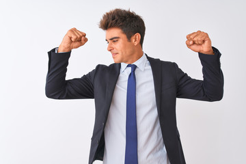 Young handsome businessman wearing suit standing over isolated white background showing arms muscles smiling proud. Fitness concept.