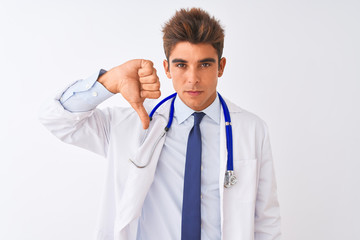 Young handsome doctor man wearing stethoscope over isolated white background looking unhappy and angry showing rejection and negative with thumbs down gesture. Bad expression.