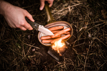 Sausages fried in a pan of a military pot