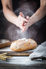 Baker cooking bread. Man slaps flour over the dough. Man's hands Making bread