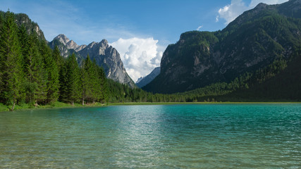 Fototapeta na wymiar View of Dobbiaco Lake and surrounding mountains. Dolomites, Italy