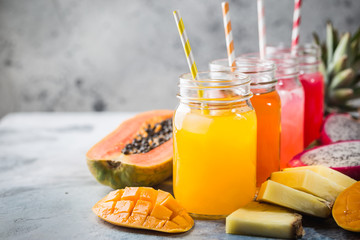 Glasses of tasty fresh tropical juices with fresh tropical fruits, Papaya Pine Apple Mango Dragon...