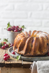 Fresh homemade bundt cake with cherry on wooden table