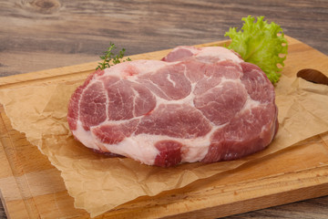 Raw pork steak over wooden board