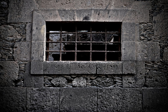 A prison cell, a barred window.