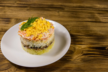 Traditional russian salad Mimosa on wooden table